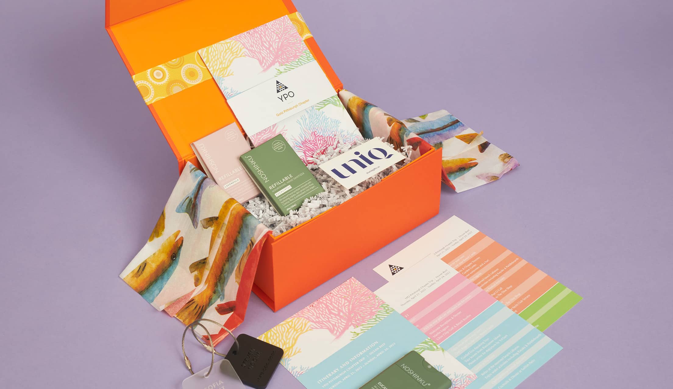 Gift box with custom itinerary, luggage tags, and hand sanitizer for a destination event