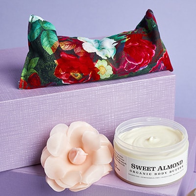 An organic eye pillow with flax, organic body butter and handcrafted floral soap in a welcome wedding gift box